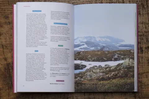Ein kleines Haus in der norwegischen Berglandschaft, Schnee und Felsen. Ein Zug durch Europa ist hier eine Reise wert.