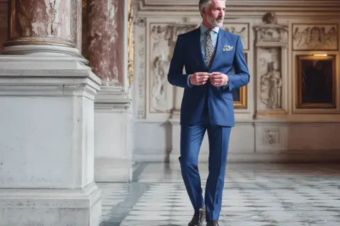 Elegante Abschlussfeier Kleidung für Eltern: Ein stilvoller Mann im blauen Nadelstreifenanzug, bereit für den besonderen Anlass.