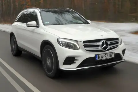 Biały Mercedes-Benz GLC w ruchu drogowym. Wiele osób szuka takich aut, sprawdzając mercedes glc opinie.