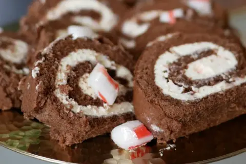 Chokladrulltårta med fluffig grädde och bitar av godis. En härlig dessert som passar perfekt till fikat.