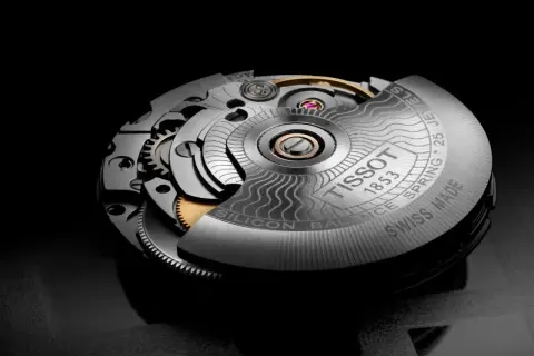 Mecanismo de reloj Tissot con el calibre Powermatic 80, mostrando engranajes y detalles grabados.