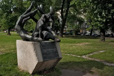 Pomnik psa Dżoka, wiernego towarzysza, siedzi w dłoniach, symbolizując oddanie i miłość.
