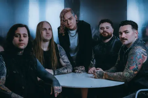 Zespół Lorna Shore Polska przy okrągłym stole, z tatuażami i w mrocznym klimacie.
