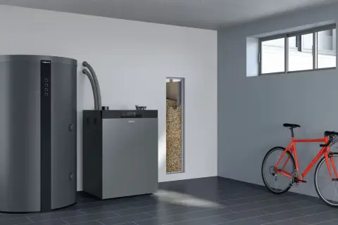 Nowoczesny piec na pellet Viessmann i zasobnik paliwa. Idealny, jaki piec na pellet do domu 120m2. Obok rower.