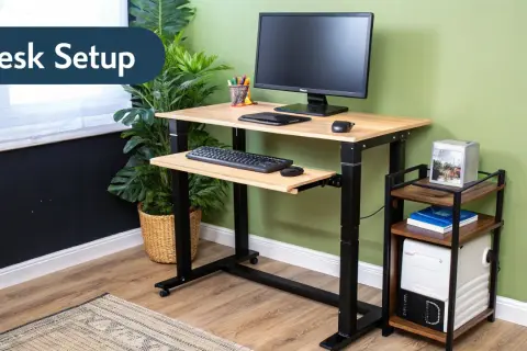 Adjustable height computer desk setup with monitor, keyboard, and mouse. A small side table holds a computer tower and books.
