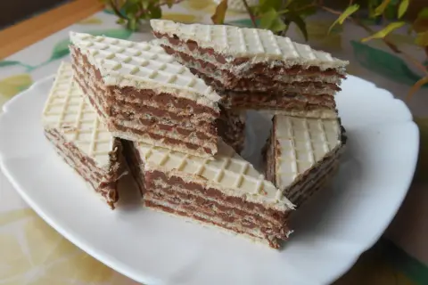 Kawałki wafli z kremem czekoladowym, przypominające smakiem wafle z mlekiem w proszku, ułożone na białym talerzu.