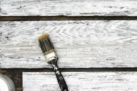 Pennello sporco su assi di legno verniciato con cementite, effetto shabby chic.