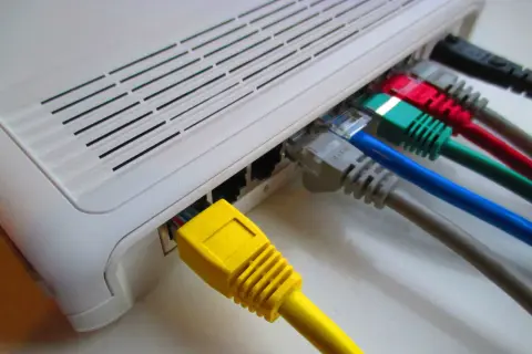 Router z wieloma kolorowymi kablami Ethernet. Stabilny internet po kablu to podstawa.