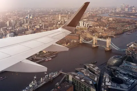 Flygplansvinge över London med Tower Bridge och floden Themsen. En vy som påminner om ankomsten till en av Londons flygplatser.