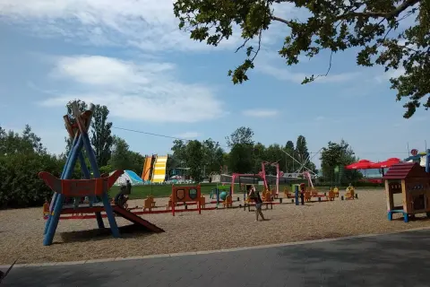 Plac zabaw z atrakcjami dla dzieci nad Balatonem: zjeżdżalnie, huśtawki i domek.