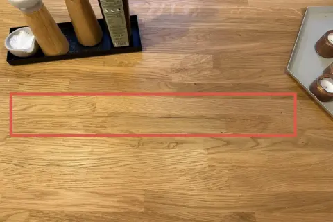 Une fissure visible sur une table en bois, nécessitant une réparation.