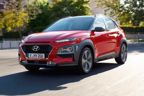 Czerwony Hyundai Kona w ruchu ulicznym. Sprawdź jego kompaktowe hyundai kona wymiary, idealne do miasta.