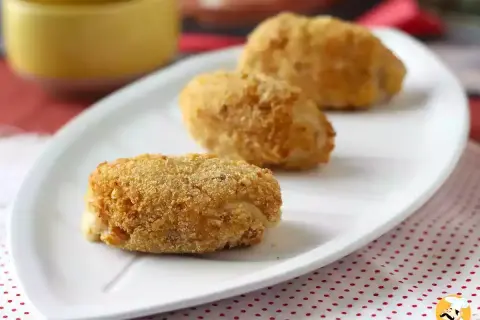 Trois croquetas espagnoles dorées et croustillantes sur une assiette blanche.