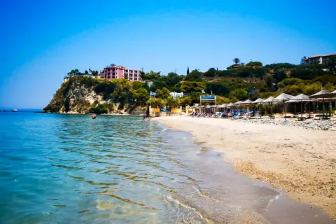 Piękna plaża Alykanas z turkusową wodą, piaszczystym brzegiem i hotelami na klifie. Idealne miejsce na wakacje.