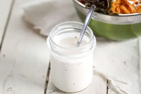 Frisches Joghurt Dressing selber machen ist einfach! Hier ein Glas mit cremiger, selbstgemachter Joghurt-Dressing-Basis, bereit für den Salat.