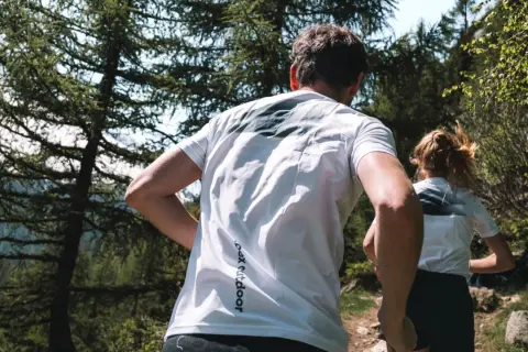 Couple en pleine course en forêt, profitant d'un moment de sport aérobie en pleine nature.