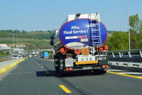 Camion ADR Carrefour sur l'autoroute, transportant du fioul. La citerne bleue affiche "Allo, Fioul Service!".