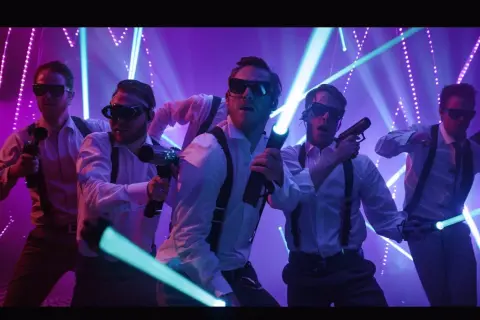 Gruppo di amici in camicia bianca e bretelle, occhiali da sole e pistole laser, pronti per un addio celibato o nubilato in un tripudio di luci.