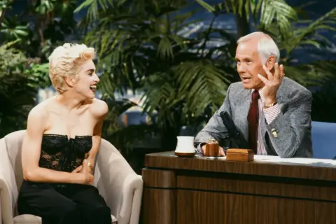Madonna śmieje się podczas wywiadu, wspominając swoje czasy na "Isla Bonita". Johnny Carson słucha jej z uwagą.