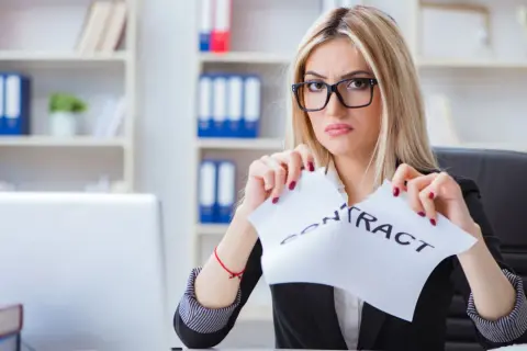 Zdeterminowana kobieta zrywa umowę, symbolizując rozwiązanie umowy leasingu przed upływem 2 lat.