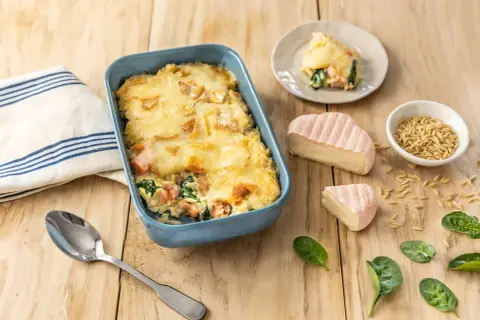 Un plat gratiné de saumon et épinards, parfait pour un repas du soir familial rapide. Accompagné de fromage et de pâtes orzo.