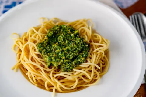 Spaghetti mit einem Berg von leckerem Pistazien Pesto, garniert mit gehackten Pistazien.