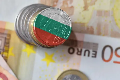 Monety z flagą Bułgarii, symbolizujące lew bułgarski, leżą na banknotach euro.