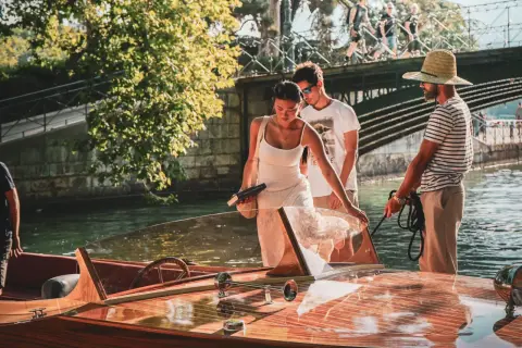 Couple profitant d'une activité à Annecy, embarquant sur un bateau en bois.