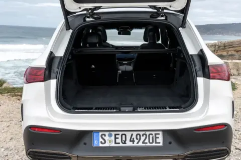 Maletero abierto de un Mercedes EQA blanco, listo para cargar equipaje en un viaje a la costa.