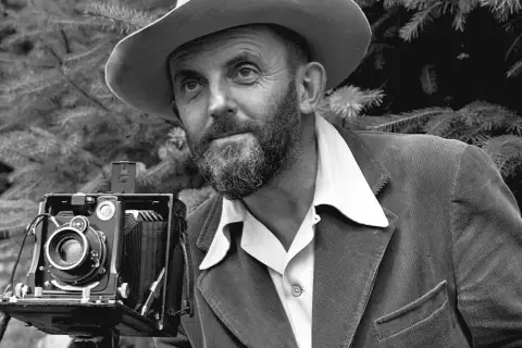 Uomo con cappello e barba, con una vecchia macchina fotografica. Potrebbe essere il best photographer in the world.