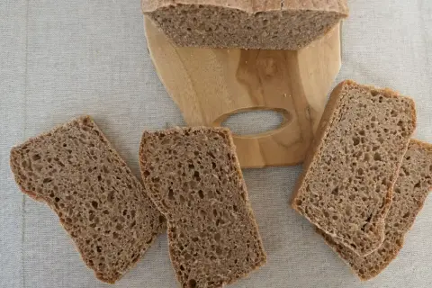 Kromki ciemnego chleba na desce, aż chce się jeść, ale potem może pojawić się zgaga po chlebie.