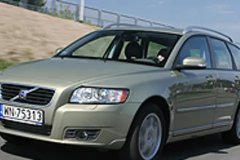 Złoty Volvo V50 2.0D na drodze, z widocznym kierowcą za kierownicą.