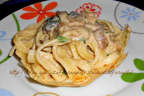 Scialatielli ai funghi cremosi serviti in un cestino croccante, un piatto invitante e saporito.