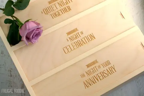Drewniane pudełko na wino z grawerem "A Quiet Night Together", "A Night of Celebration", "The Night of Your Anniversary" i różową różą.