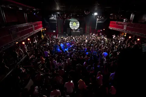 Folla in delirio al Nitsa Club, luci soffuse e musica pulsante.