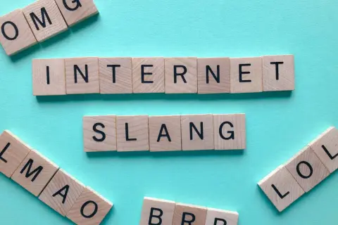 Letras de madera forman "INTERNET SLANG", "OMG", "LMAO" y "LOL". ¡El lenguaje de mañana abreviado!