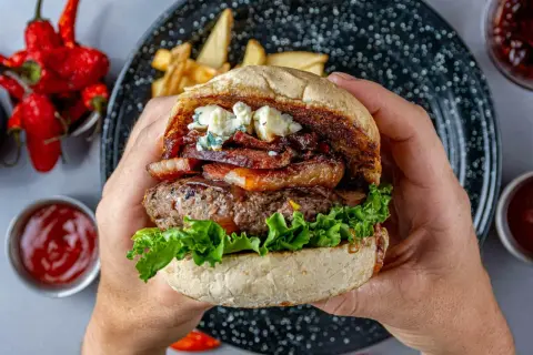 Soczysty burger z udźca wołowego, boczkiem, serem pleśniowym i chrupiącą sałatą. Idealny na letnie grillowanie.