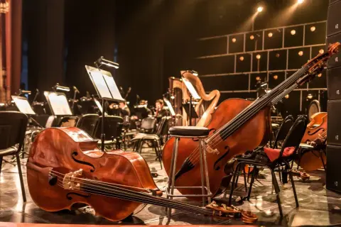 Kontrabasy i harfa na scenie, gotowe do wykonania muzyki z filmów.