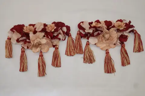 Dos adornos florales con borlas rojas y doradas, perfectos para saber como hacer hombreras flamencas.