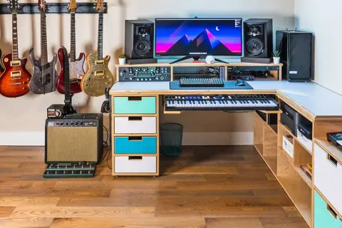 A musician's dream setup for computer music creation, featuring guitars, keyboards, speakers, and a powerful computer.
