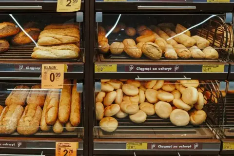 Na półkach sklepowych widać świeże pieczywo: bułki z ziarnami, bagietki i chlebki. Idealne na śniadanie, choć warto sprawdzić bułka z ziarnami kcal.