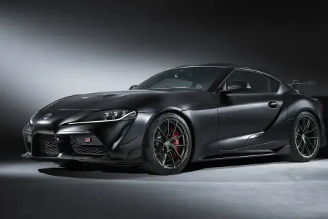 Mroczna Toyota GR Supra z matowym czarnym lakierem i agresywnym spojlerem, gotowa do podboju toru.
