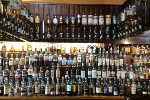Wielka półka pełna butelek szkockiego piwa i whisky, gotowych do degustacji.