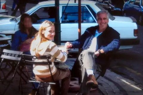 Jeffrey Epstein i młoda kobieta siedzą przy stoliku. Scena przypomina ujęcie z filmu "Wyspa Epsteina".
