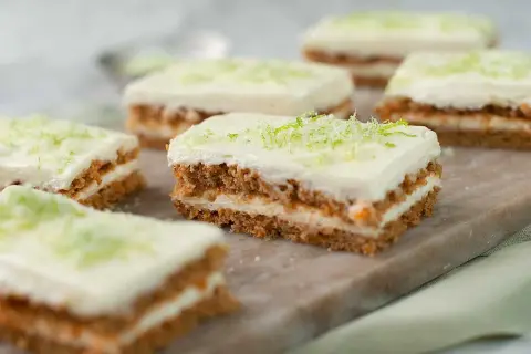 Små bitar av saftig morotskaka med krämig frosting och rivet limeskal. Perfekt för ett enkelt morotskaka recept.
