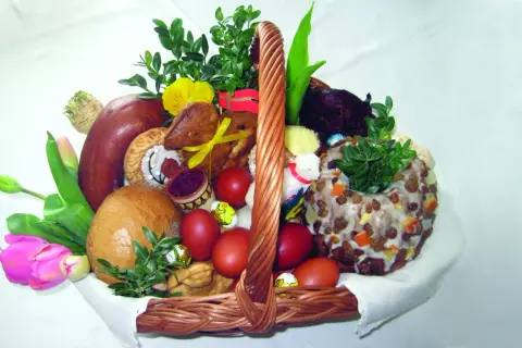 Koszyk wielkanocny z tradycyjnym święceniem pokarmów: chleb, kiełbasa, jajka, babka, zieleń i ozdoby.