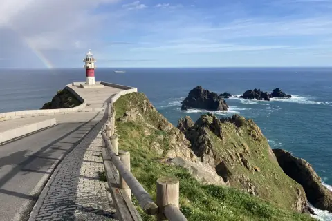 Faro en Cabo Ortegal con arcoíris. Un paisaje espectacular que ver, con el mar azul y rocas escarpadas.