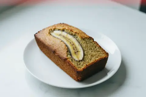 Chlebek bananowy z airfryera, idealnie wypieczony, z plasterkiem banana na wierzchu.