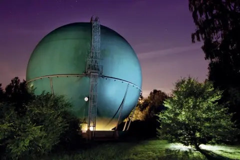Grüne Kugel des Galileum Solingen leuchtet im Sternenhimmel.