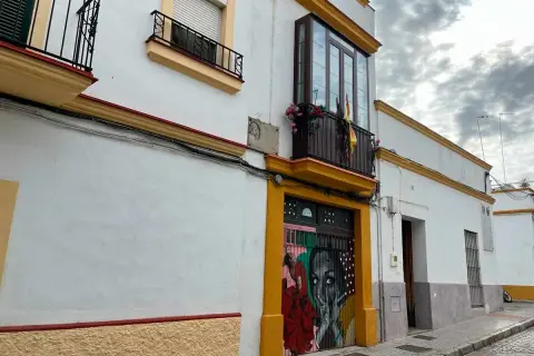 Fachada de la casa Lola Flores en Jerez, con un mural vibrante en la puerta y balcones adornados.